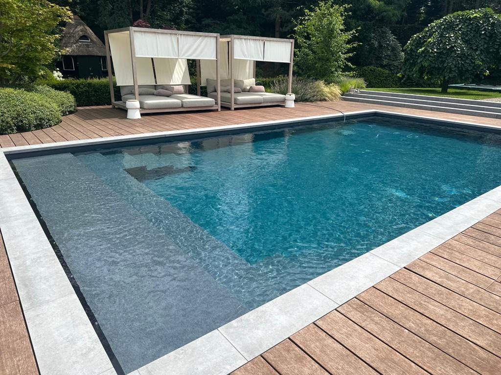 Zwembad met houten vlonder en lamellenafdekking in een bosrijke tuin in Vught